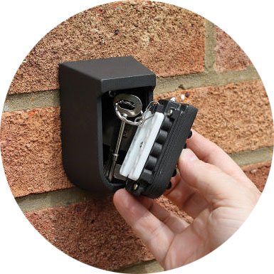 A user takes a key out of an Outside Security Key Safe