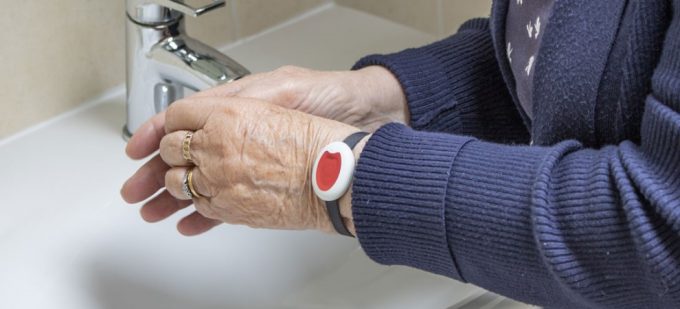 Woman washing her hands while wearing a Pendant Alarm on her wrist