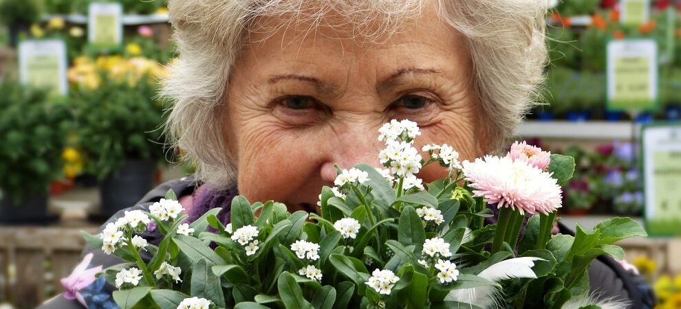 elderly woman with flowers from gardening springtime activities